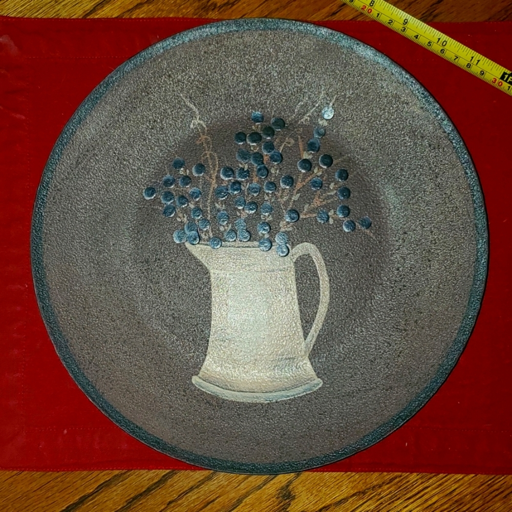 Primitive plate with pitcher and blue berrie twig inside vase